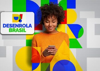 Mulher de blusa laranja sorrindo enquanto utiliza celular ao lado do logotipo do Desenrola Brasil