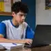 Estudante acessando notebook em ambiente de estudos, representando a inscrição no Enem 2026.