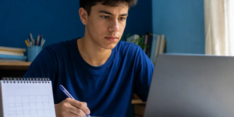 Estudante brasileiro atento diante do notebook, representando o acompanhamento da abertura das inscrições do Enem 2026.