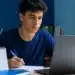 Estudante brasileiro atento diante do notebook, representando o acompanhamento da abertura das inscrições do Enem 2026.