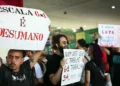 Manifestantes erguendo cartazes com mensagens contra a escala 6x1 durante protesto público