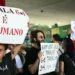 Manifestantes erguendo cartazes com mensagens contra a escala 6x1 durante protesto público