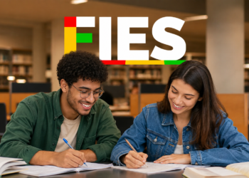 Jovem de óculos e camisa verde e mulher de jaqueta jeans estudam em biblioteca com logo colorido do FIES.