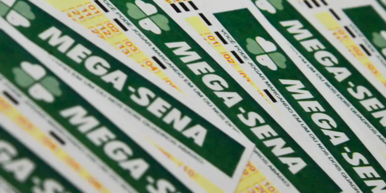 Vários volantes da Mega-Sena empilhados exibindo logo verde e amarelo das Loterias Caixa