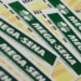 Vários volantes da Mega-Sena empilhados exibindo logo verde e amarelo das Loterias Caixa