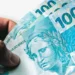 Notas de cem reais ilustrando o novo salário mínimo de R$ 1.874 aprovado pela Assembleia Legislativa.