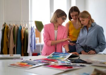 Profissionais analisam paleta de cores em estúdio de moda, representando carreiras ligadas ao universo de O Diabo Veste Prada 2.