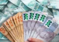 Cédulas de real em destaque representando o pagamento de R$ 1.486 confirmado para CPFs com todos os finais.