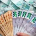 Cédulas de real em destaque representando o pagamento de R$ 1.486 confirmado para CPFs com todos os finais.