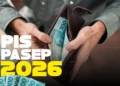 Carteira aberta com notas de 100 reais e identificação do PIS/Pasep 2026, representando o pagamento confirmado de R$ 1.351.