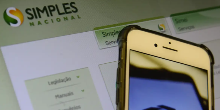 Tela de smartphone com logos da Receita Federal, Simples Nacional e Microempreendedor Individual ao lado de calculadora cinza e agenda azul