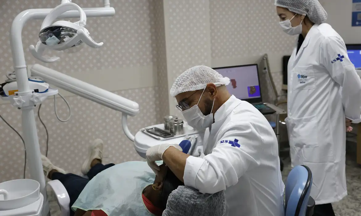 Cirurgião-dentista realiza atendimento em consultório do SUS, em referência ao projeto de lei que reajusta o piso salarial da categoria.