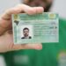 Homem exibindo a Carteira Nacional de Habilitação brasileira em destaque para a câmera