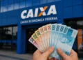 Saque de notas de real em frente à agência da Caixa Econômica Federal, relacionado à liberação de R$ 6.220 para novos brasileiros.