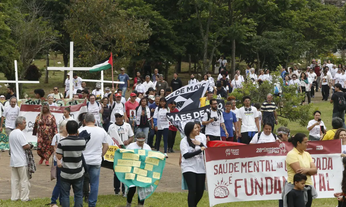 Manifestantes erguem faixa em defesa da saúde mental, tema agora incluído no Estatuto da Criança e do Adolescente