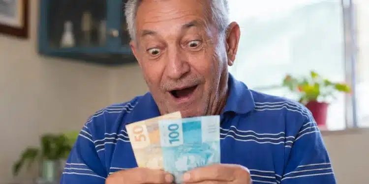 Idoso segurando notas de dinheiro, representando o pagamento de R$ 8.475,55 do INSS e da segunda parcela do 13º nesta semana