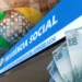 Fachada da Previdência Social com notas de dinheiro ao fundo representando o pagamento da segunda parcela do 13º do INSS