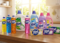 Produtos Ypê enfileirados em bancada de cozinha: detergentes coloridos, amaciantes florais e sabão em barra.