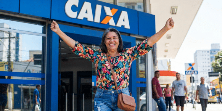 Mulher sorridente celebra conquista em frente à agência da Caixa.