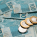 Notas de 100 reais e moedas de 1 real.