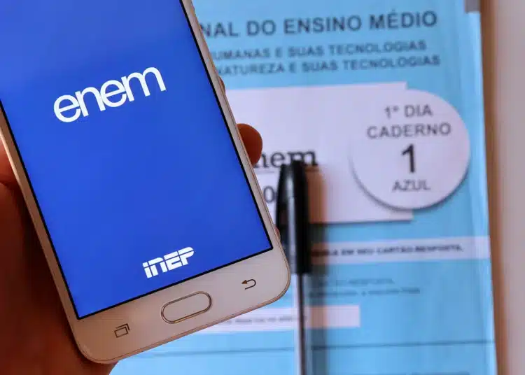 Aplicativo do Enem INEP ao lado do caderno azul do exame nacional 2026.
