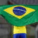 Atleta segurando a bandeira do Brasil em campo.