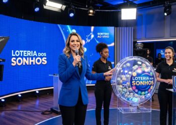 Apresentadora anuncia sorteio da Loteria dos Sonhos ao vivo com máquina de bolas e equipe no estúdio