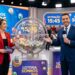 Apresentadores em estúdio exibem globo de sorteio da Loteria dos Sonhos com bolas numeradas
