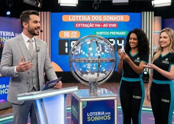 Apresentador e duas assistentes mostram a bola 24 no sorteio ao vivo da Loteria dos Sonhos às 14h.