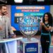 Apresentador e duas assistentes mostram a bola 24 no sorteio ao vivo da Loteria dos Sonhos às 14h.