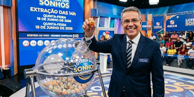 Apresentador segurando bola 43 no sorteio da Loteria dos Sonhos com painel e público ao fundo