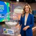 Apresentadora loira em estúdio conduz sorteio da Loteria dos Sonhos ao lado de globo transparente com bolas numeradas
