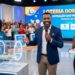 Três apresentadores da Loteria dos Sonhos mostram bolas sorteadas 19, 06, 26 e 08 em estúdio colorido