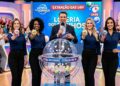 Quatro mulheres exibem bolas 18, 42, 07 e 65 ao lado de apresentador com microfone, cenário de Loteria dos Sonhos