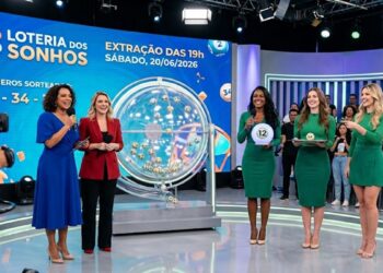 Duas apresentadoras sorrindo durante sorteio da Loteria dos Sonhos, número 12, exibido em estúdio moderno
