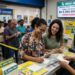 Pessoas em fila e mulheres sorrindo preenchem apostas para a Mega-Sena em lotérica