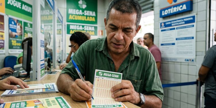 Homem de camisa verde marca números no volante da Mega-Sena dentro de lotérica, cartazes ao fundo destacam prêmio acumulado