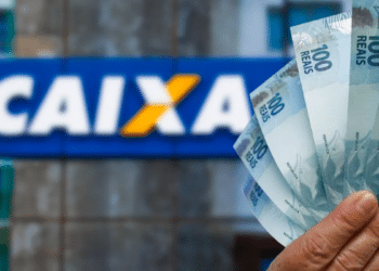 Pagamento de benefício com notas de 100 reais em frente à Caixa Econômica Federal.