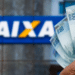 Pagamento de benefício com notas de 100 reais em frente à Caixa Econômica Federal.