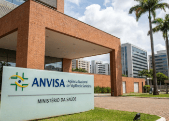 Fachada do edifício sede da Agência Nacional de Vigilância Sanitária (Anvisa) com placa institucional verde e branca.