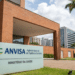 Fachada do edifício sede da Agência Nacional de Vigilância Sanitária (Anvisa) com placa institucional verde e branca.