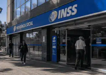 Fachada de agência do INSS com movimento de atendimento pela manhã, ilustrando mudança de horário em dia de jogo do Brasil.