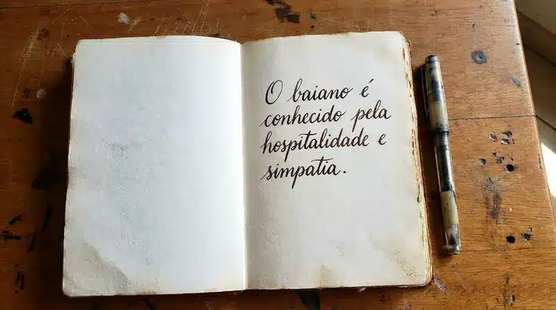 Caderno aberto com frase sobre o baiano, ilustrando o uso do gentílico sem a letra “h”.