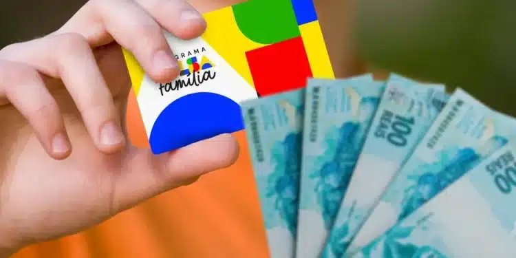 Mãos segurando cartão do Bolsa Família com cédulas de reais ao lado, representando pagamentos do benefício em julho.