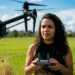 Mulher opera um drone com controle remoto em campo aberto, representando a carreira de piloto de drone que pode pagar mais de R$ 10 mil
