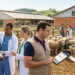 Veterinários e pesquisadores analisam vaca e ovelhas ao ar livre em centro agropecuário.