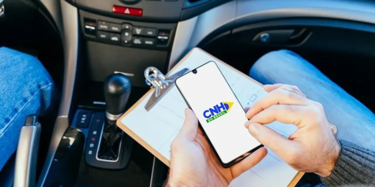 Candidato consulta informações da CNH pelo celular dentro de um carro durante processo de habilitação.