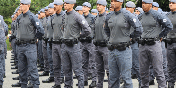 Imagem de policiais militares da Polícia Militar do Estado de São Paulo (PM SP) caminhando em formação em ambiente urbano. A cena ilustra o anúncio do novo concurso público com 4 mil vagas para o cargo de Aluno-Soldado PM, com previsão de posse nos anos de 2028, conforme autorização publicada pelo governo estadual.