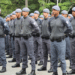 Imagem de policiais militares da Polícia Militar do Estado de São Paulo (PM SP) caminhando em formação em ambiente urbano. A cena ilustra o anúncio do novo concurso público com 4 mil vagas para o cargo de Aluno-Soldado PM, com previsão de posse nos anos de 2028, conforme autorização publicada pelo governo estadual.