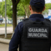 Guarda municipal de costas em ambiente urbano representando concurso público com vagas abertas.